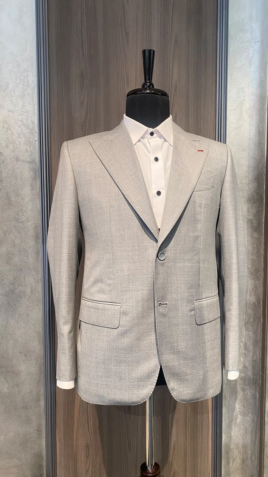 Light grey handmade suit jacket with a red lapel buttonhole detail by The Man Project