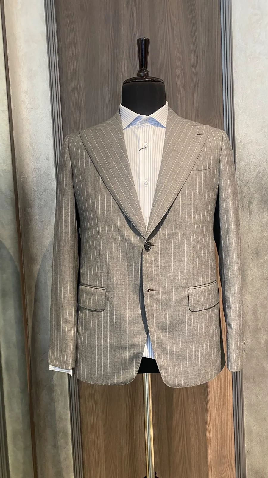 Front of a grey pinstripe bespoke suit jacket by The Man Project